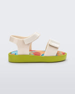 Side view of a beige baby Jump sandal with green sole