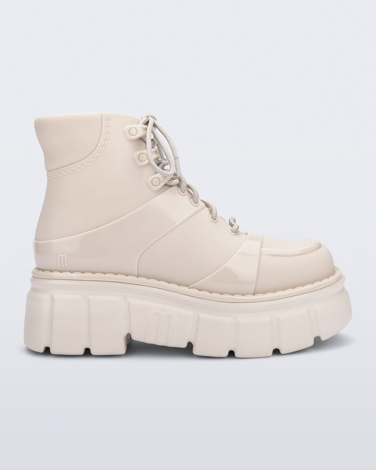 Side view of a beige Rebel boot with laces