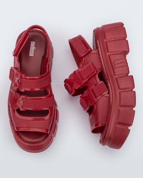 Side and top view of a pair of red Rebel platform Sandals with back strap.