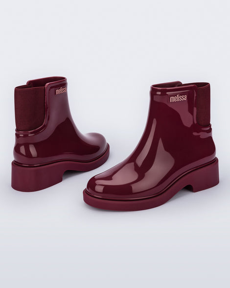 Back and angled view of a pair of burgundy red Chelsea Boots.