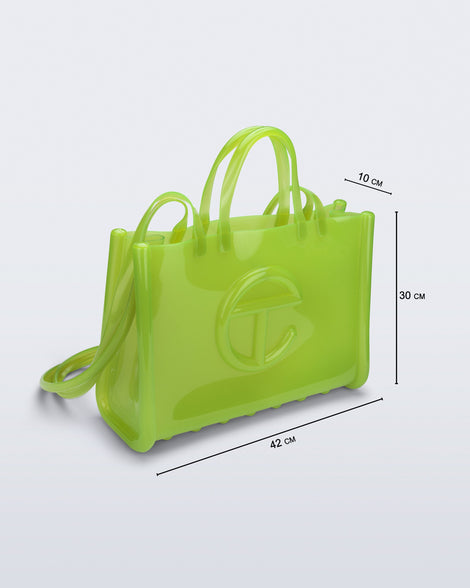 Angled view of the green Large Jelly Shopper x Telfar bag with dimensions: 42 cm x 10 cm x 30 cm