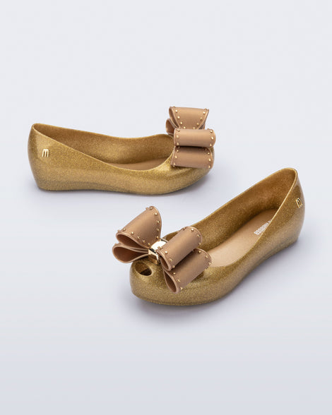 Angled view of a pair of pearly beige kids Ultragirl Classic Bow kids flats