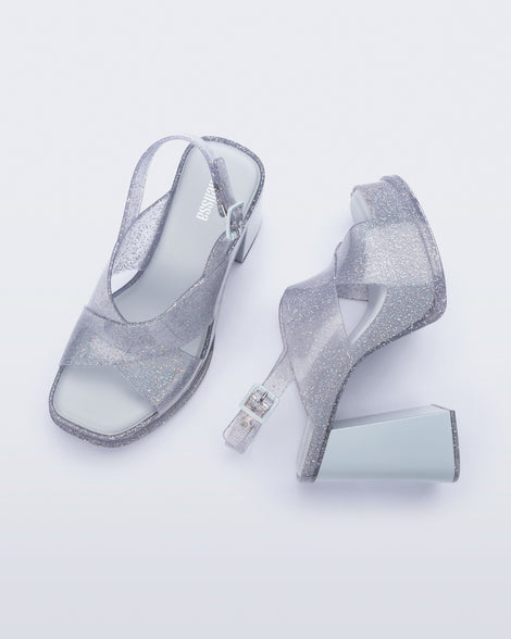 Top and side view of a pair of clear glitter Dance Heel platforms