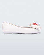 Side view of a white Sweet Love Snow White kids flat with a white bow with red apple center