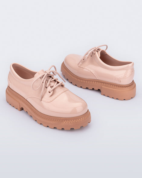 Angled view of a pair of pink with brown sole Charlotte adult sneaker loafers with laces