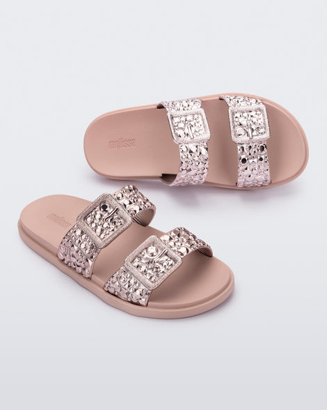 Top and angled view of a pair of pink Lust Slide with metallic buckle straps