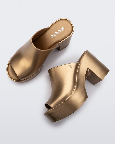 Top and side view of a pair of gold Mule Hype Platforms