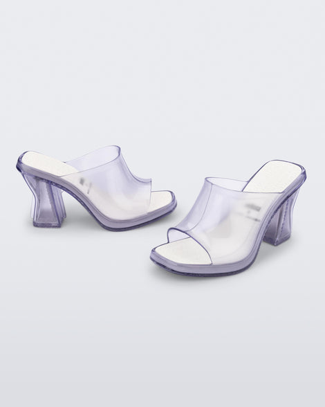 Side and angled view of a pair of clear Mule + Marc Jacobs heels.