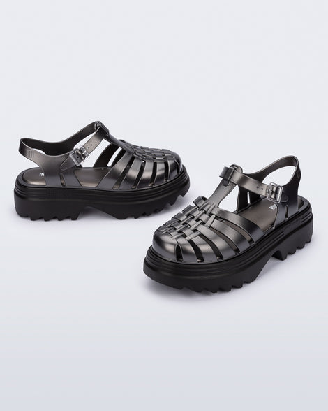 Side and angled view of a pair of silver Possession Platform II sandals with black sole.