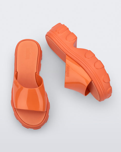 Side and top view of a pair of orange Ella slide platforms