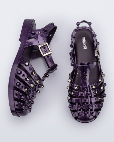 Side and top view of a pair of purple Possession Studs fisherman sandals with silver studs.