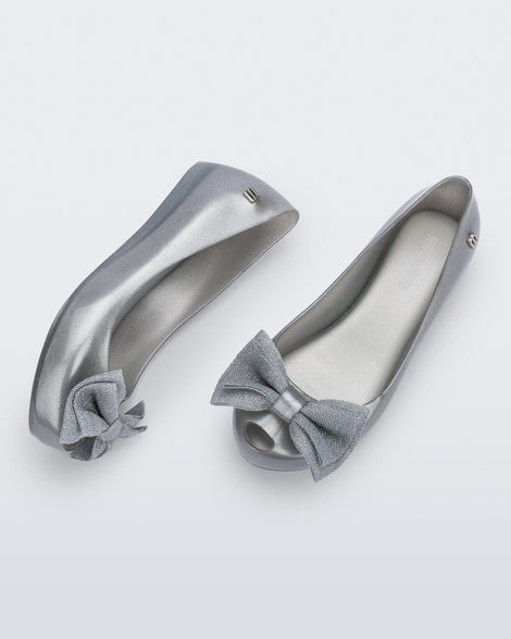 Top and side view of a pair of pearly silver Ultragirl Sweet kids ballerina flats with bow