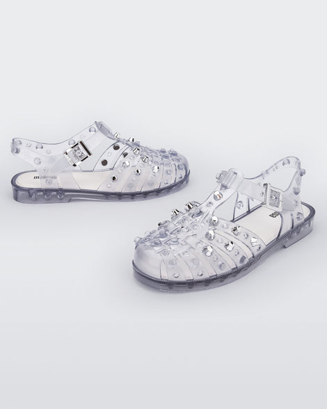 Side and angled view of a pair of clear Possession Studs fisherman sandals with silver studs.