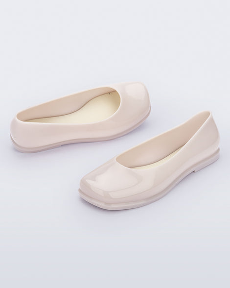 Angled view of a pair of beige Ruby adult flats.