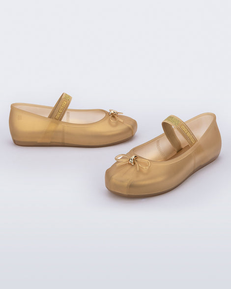 Side and angled view of a pair of pearly beige Sophie kids ballerina flats with bow