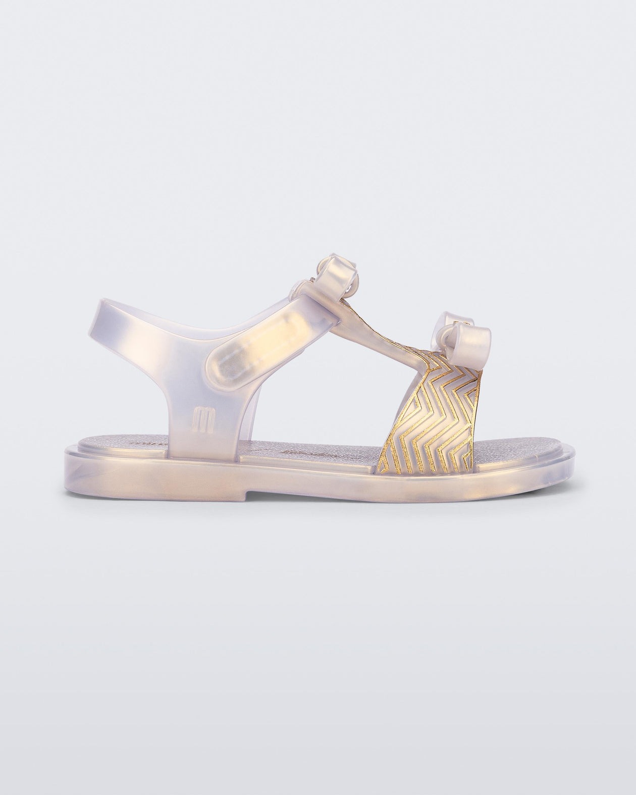 Side view of a pearly gold baby Dream Sandal with two bows and gold detail on strap