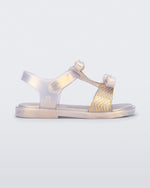 Side view of a pearly gold baby Dream Sandal with two bows and gold detail on strap