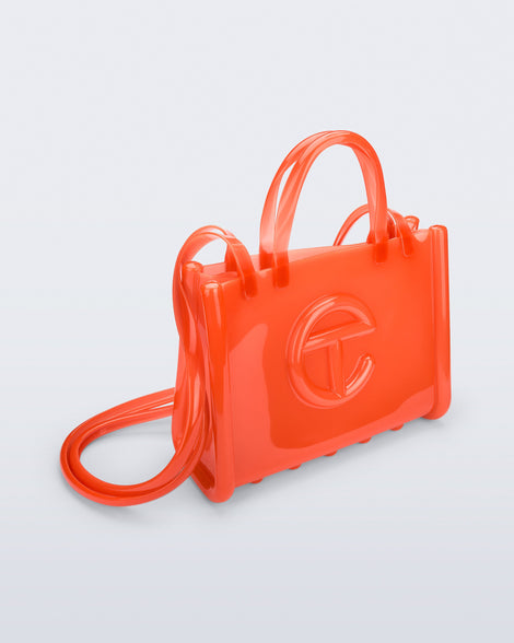 Angled view of the orange Medium Jelly Shopper x Telfar bag