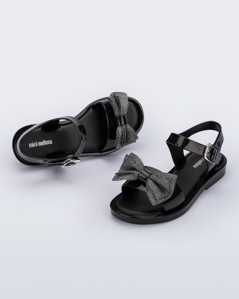 Angled view of a pair of glitter black Mar Sweet kids sandals