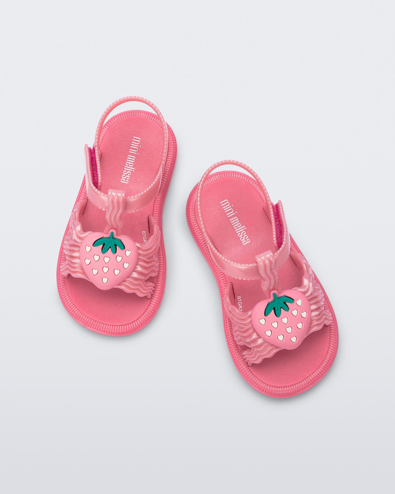 Top view of a pair of pearly pink baby Hip Sandals with pink strawberry