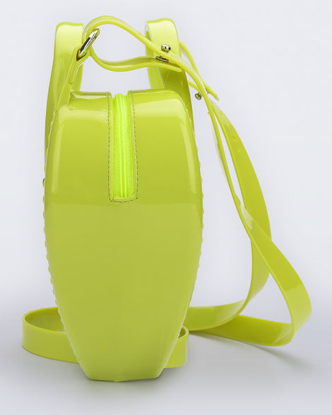 Side view of a green Heartbeat bag with small handles and longer strap.