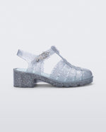 Side view of a clear glitter kids Possession Heel sandal