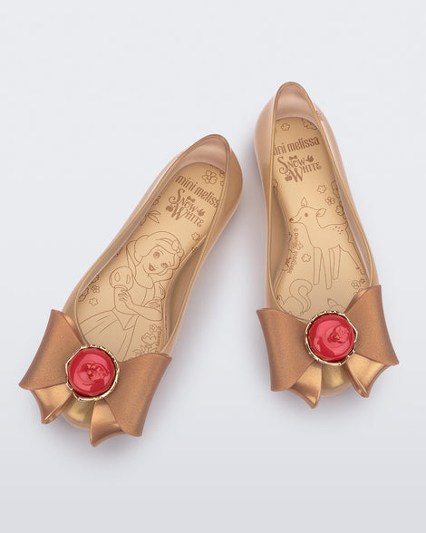 Top view of a pair of beige Sweet Love Snow White kids flats with a beige bow with red apple center