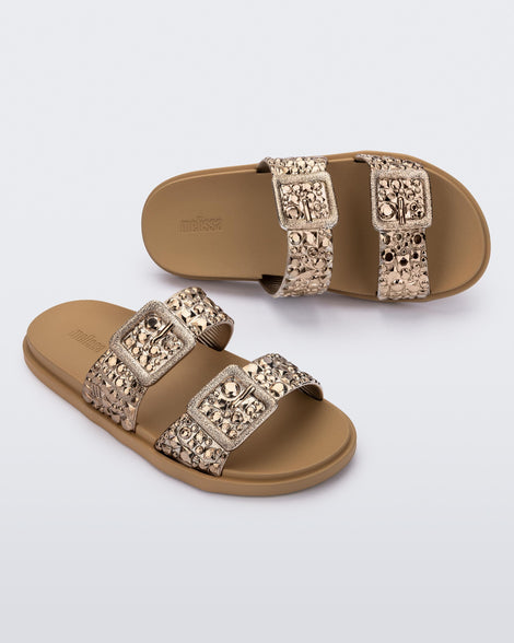 Top and angled view of a pair of beige Lust Slide with metallic buckle straps