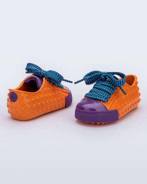 Back and angled view of a pair of orange and purple Polibolha baby sneakers with blue laces.