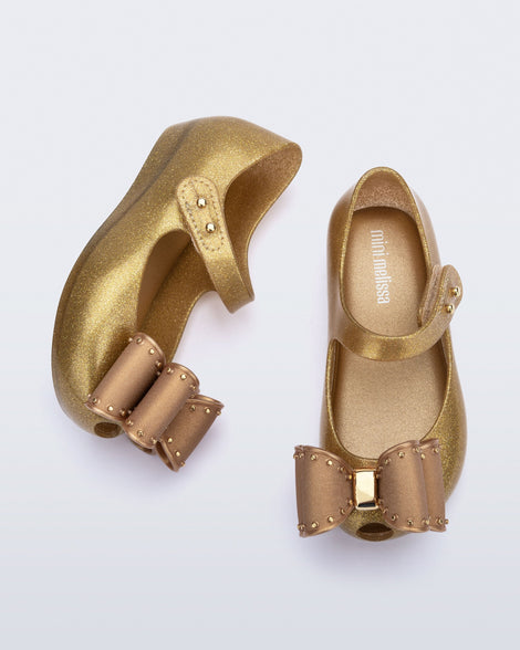 Top and side view of a pair of pearly beige baby Ultragirl Classic Bow flats