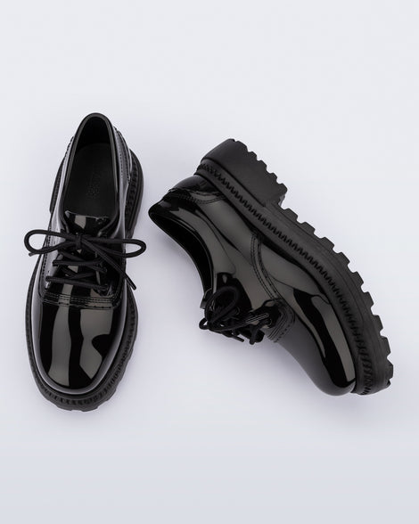 Top and side view of a pair of black Charlotte adult sneaker loafers with laces