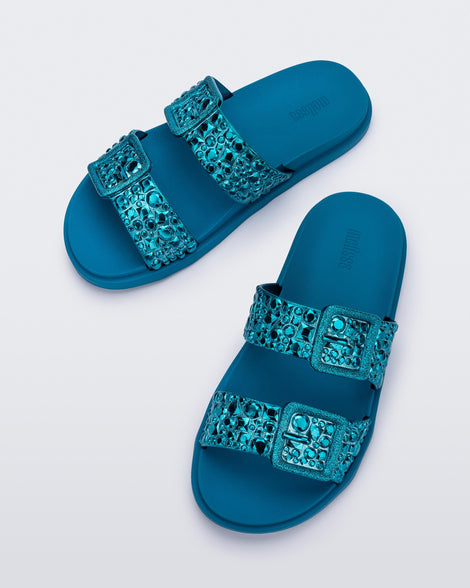 Top view of a pair of blue Lust Slide with metallic buckle straps