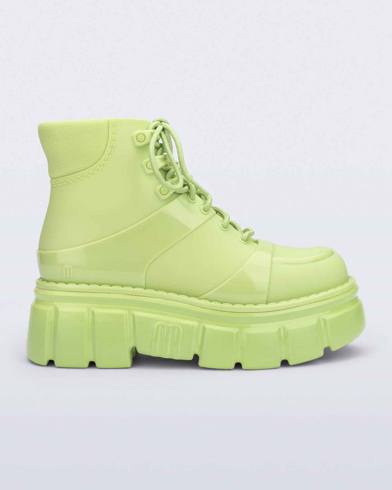 Side view of a green Rebel boot with laces