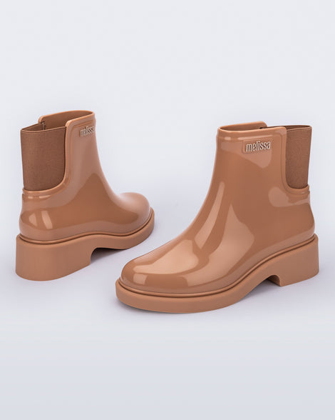 Back and angled view of a pair of brown Chelsea Boots.