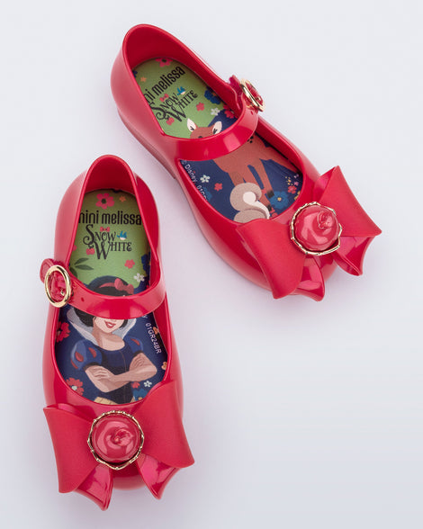 Top view of a pair of red Sweet Love Snow White baby flats with a red bow with red apple center