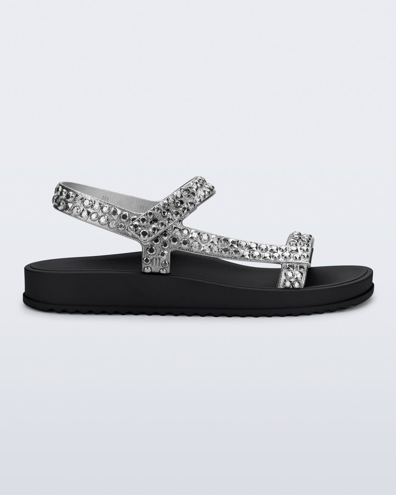 Side view of a black Lust sandal with silver strap