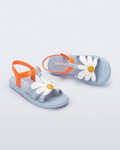 Angled view of a pair of blue and orange kids Hip Bloomy sandal.