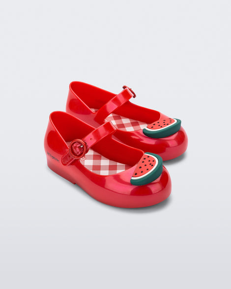 Angled view of a pair of red Sweet Love Picnic baby flats with watermelon slices