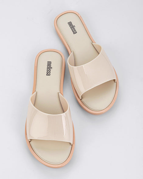 A top view of a pair of beige tortoiseshell Melissa Miranda slides