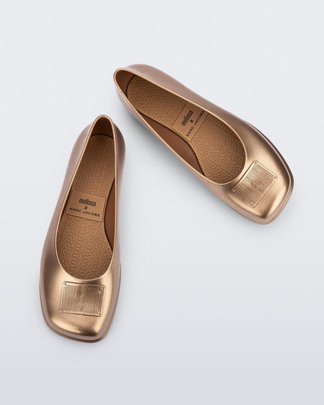 Top and angled view of a pair of metallic gold Ruby + Marc Jacobs flats