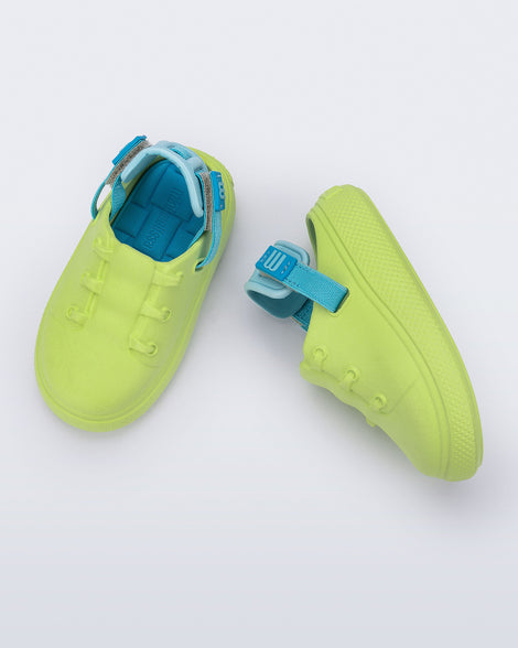 Side and top view of a pair of green with blue back strap Charlie baby sneakers