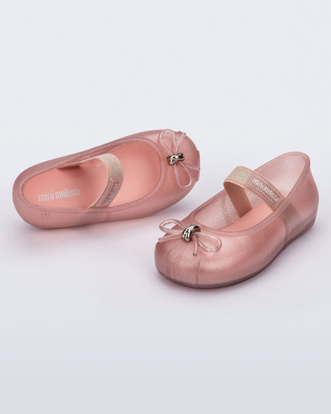 Side and angled view of a pair of pearly pink Sophie baby ballerina flats with bow