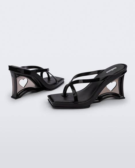 Side and angled view of a pair of black Glass Heels with a heart cutout in the heel.