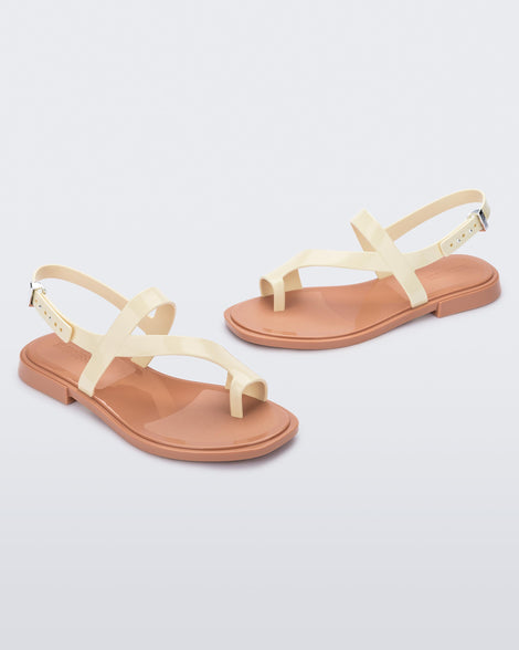 Angled view of pair of beige Cassie sandals.