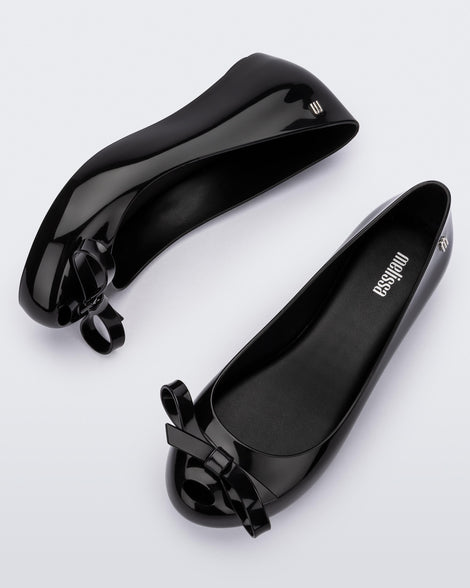 Top and side view of a pair of black Ultragirl Bow flats