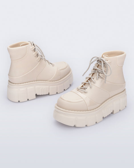 Back and side angled view of a pair of beige Rebel Boots with laces