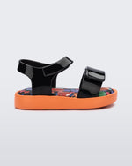 Side view of a black baby Jump sandal with orange sole