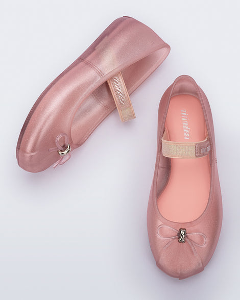 Side and top view of a pair of pearly pink Sophie kids ballerina flats with bow