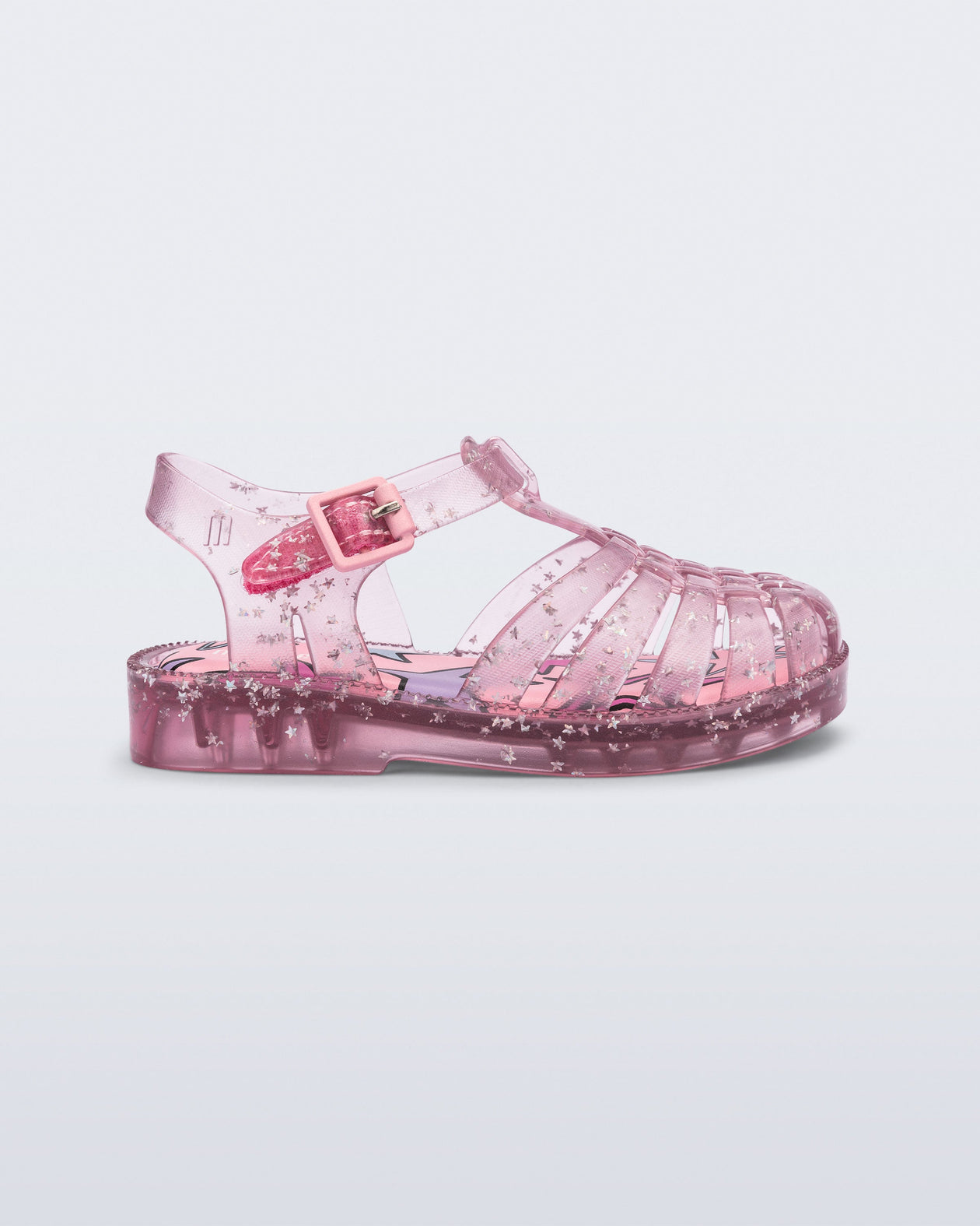 Side view of a clear pink Possession baby sandal with star glitter