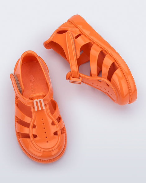 Top and side view of a pair of orange baby Hip Daydream sandals